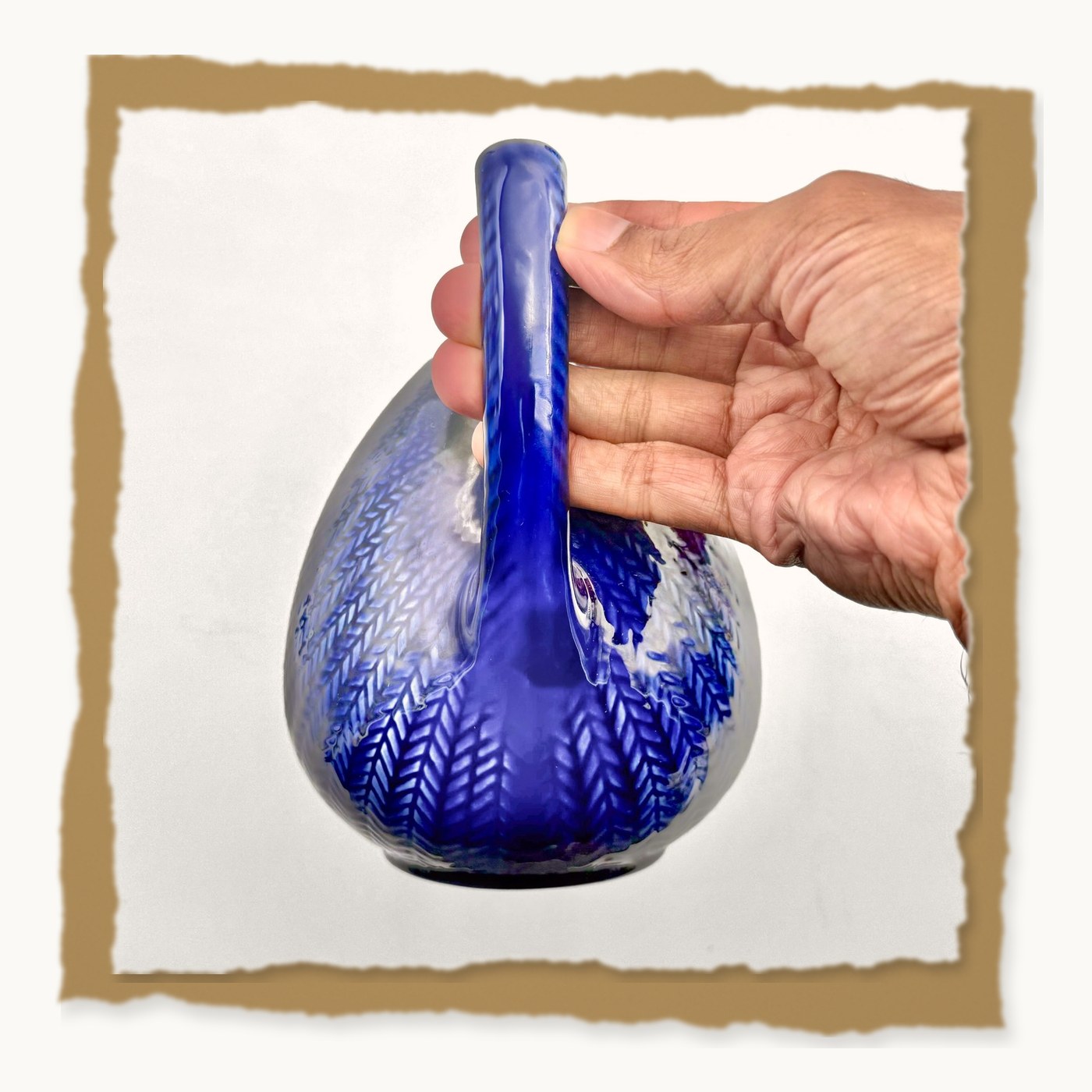 The teapot held up by its braided handle