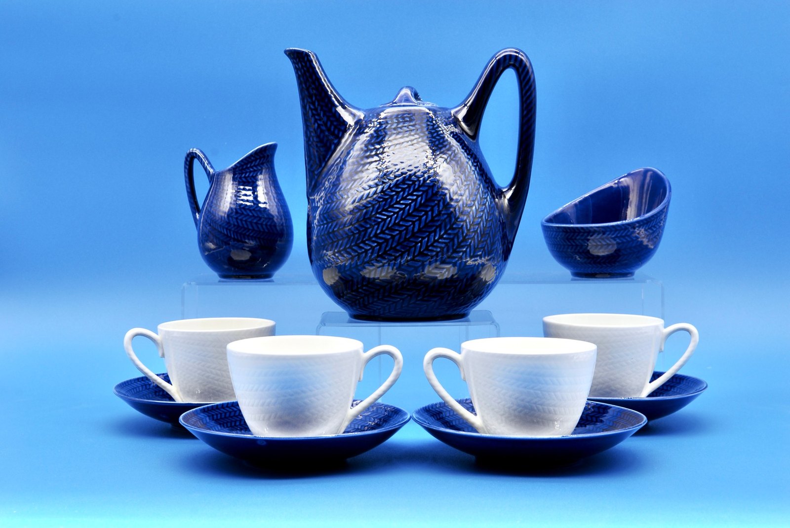 The full Blå Eld tea service: teapot, creamer, sugar bowl, and four cups with saucers